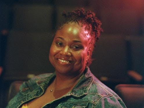 A headshot of a woman in a jean jacket