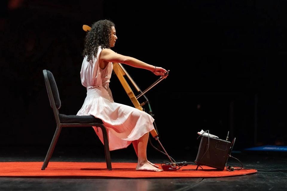 Gretchen Yanover performs on stage with her electric cello and looping pedal