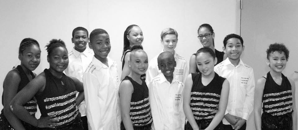 Cipher Goings and other young tap students pose for a photo in their performance costumes