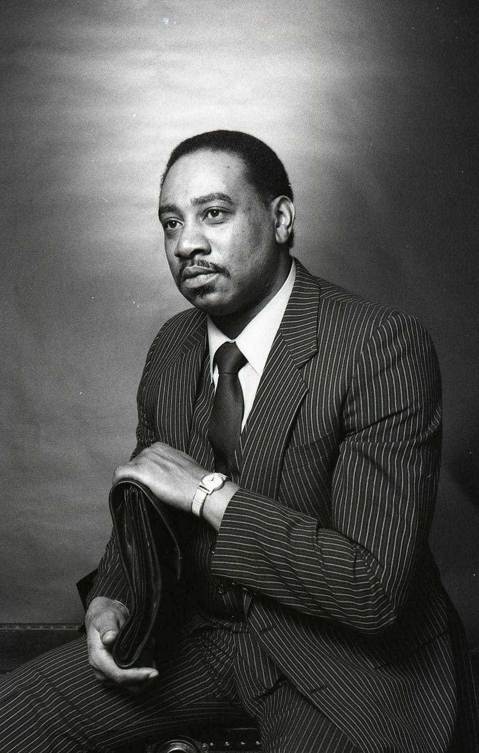 Tee Dennard wears a suit and poses for a studio portrait in the style of Martin Luther King Jr.