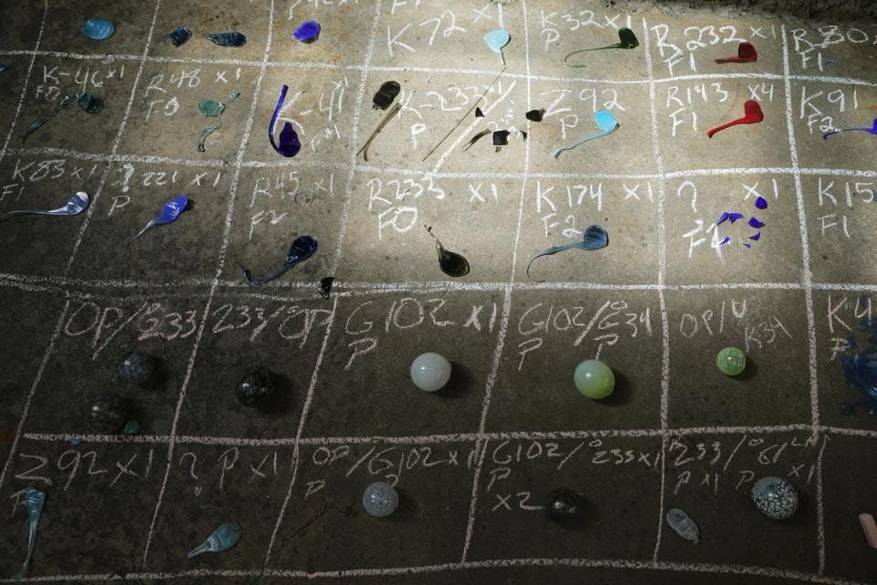 Small bits of glass in more than 20 colors, labeled in chalk 