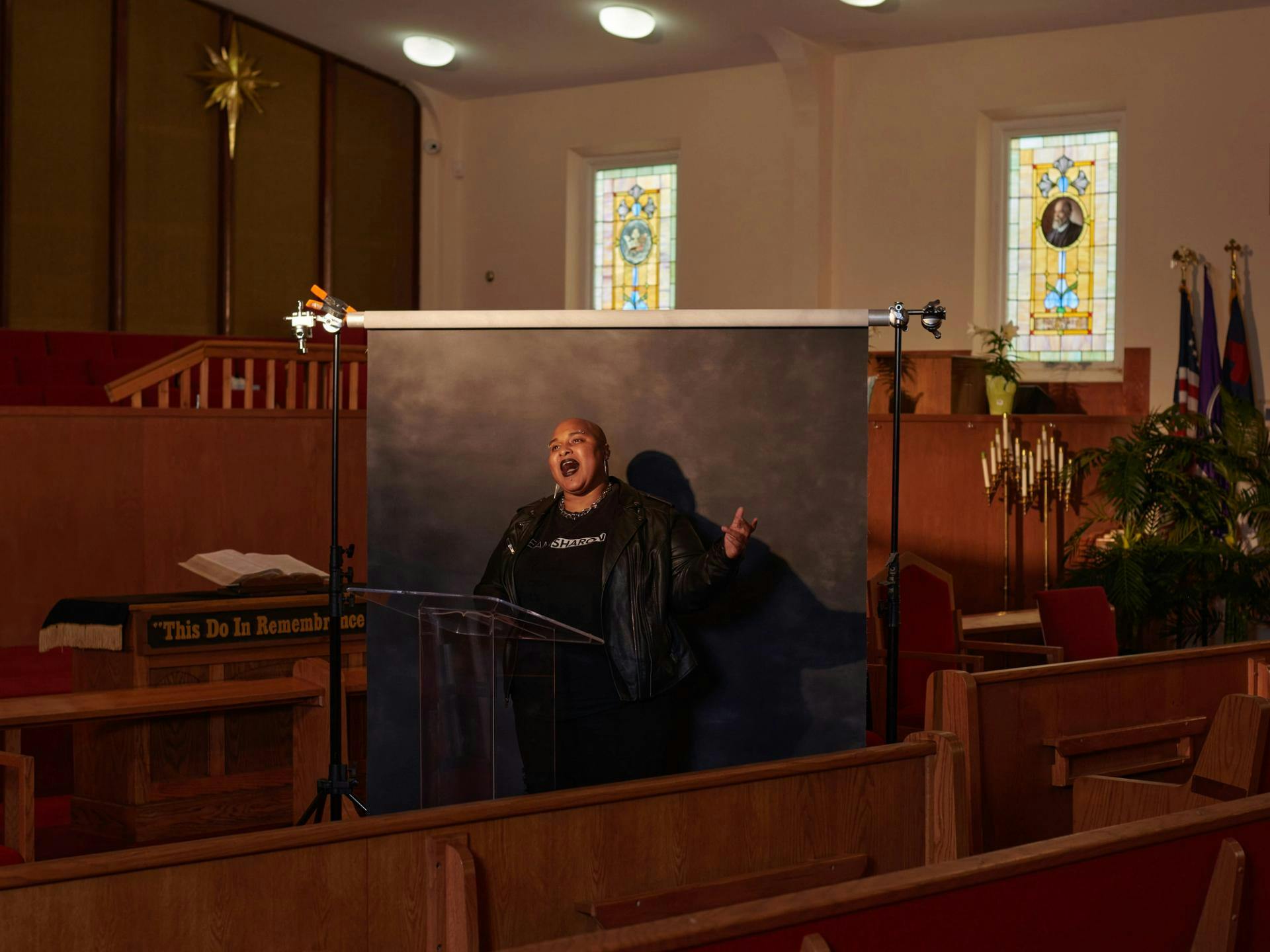 Person in front of black screen in a church-like environment
