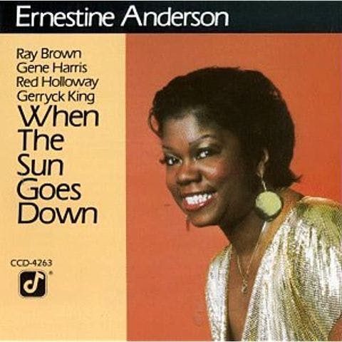 record sleeve in orange and yellow, text says "When the Sun Goes Down", on the right a photo of a smiling woman in a glittery top