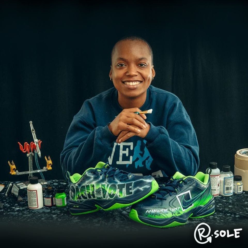 A person smiles at the camera with a pair of painted sneakers