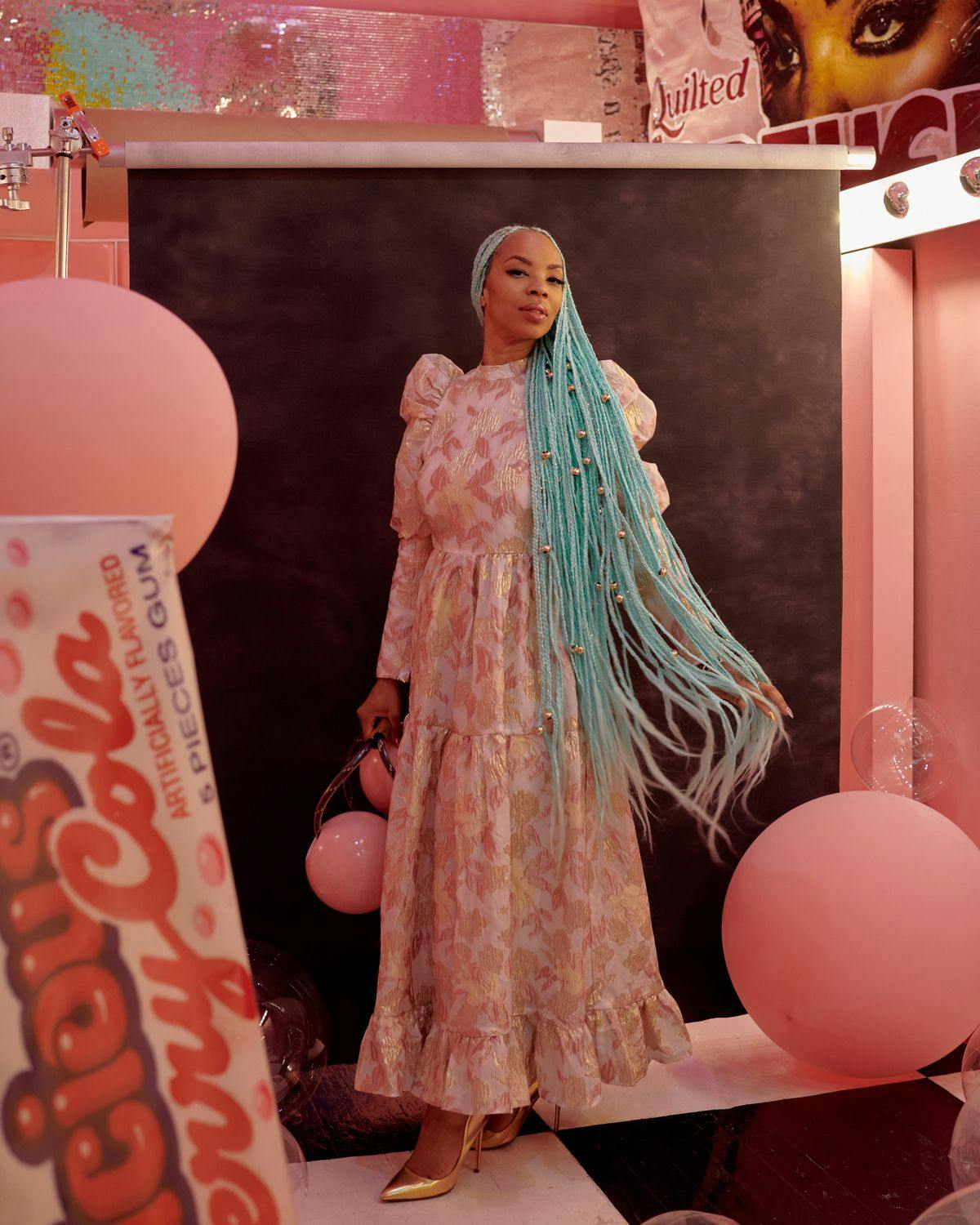 Person in pink room with blue locks and pink balls floating around