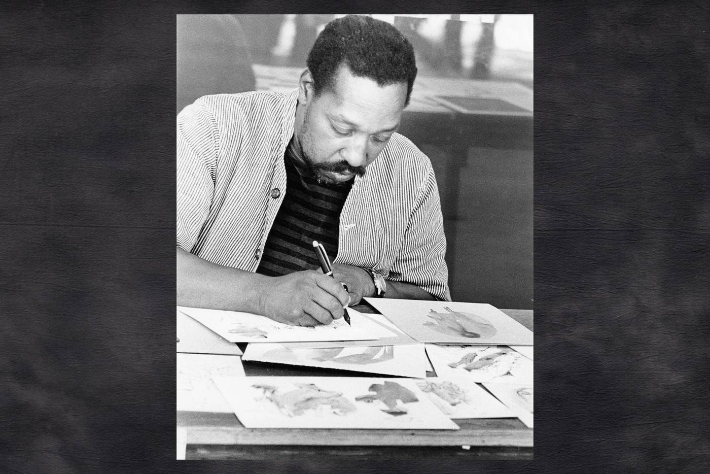 A vintage black and white photo of a man drawing