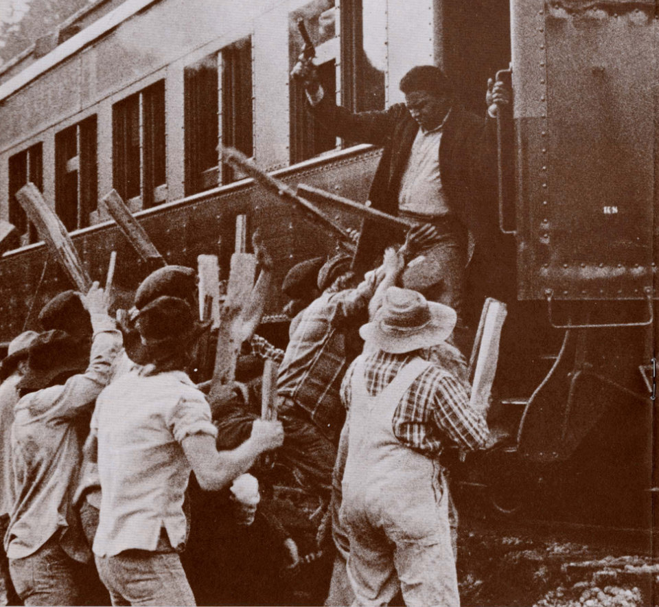 A faded photo of a man exiting a train while holding up a gun, with an angry crowd in front of him