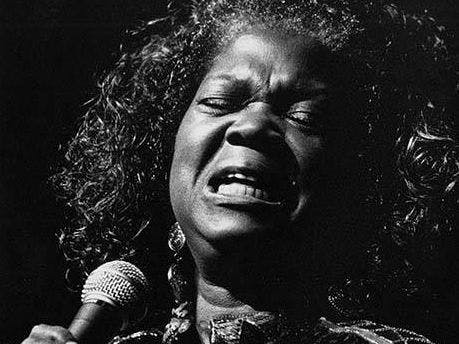 black and white image of woman singing into a microphone