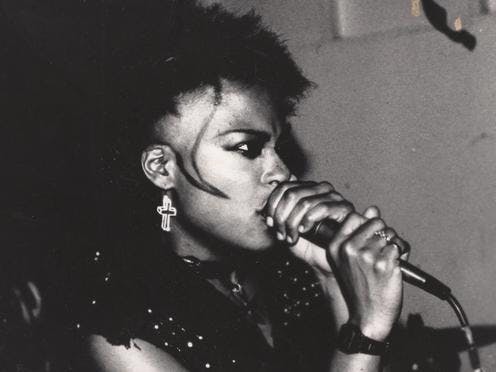 black and white image of a woman with short hair singing into a microphone